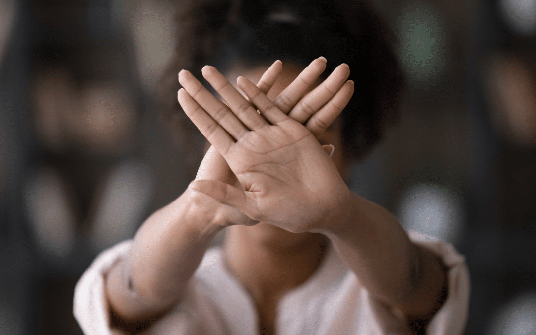 Une personne dit stop aux violences en mettant ses mains en opposition